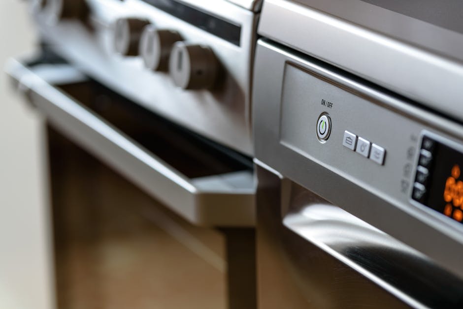 Oven not heating diagnosis: close-up of modern stainless steel kitchen appliances including a built-in oven and dishwasher
