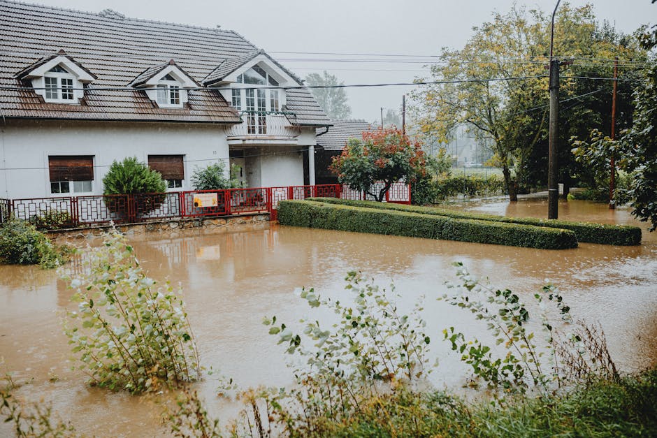 Sump pump not working consequence: a suburban house surrounded by floodwaters after heavy rain showing what happens when basement drainage fails