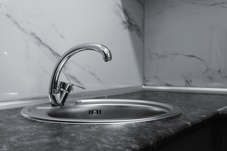 Low water pressure: stylish stainless steel kitchen faucet with sleek modern design against a marble backsplash