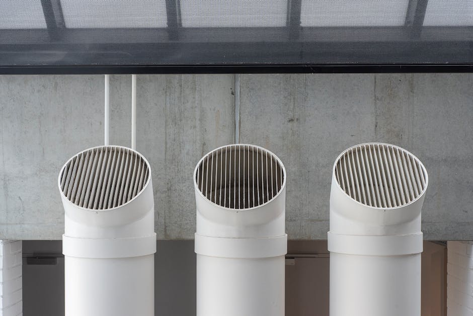 Dryer takes too long root cause illustration: three white industrial ventilation pipes aligned on a concrete wall, illustrating the kind of rigid vent ductwork that prevents a dryer takes too long problem
