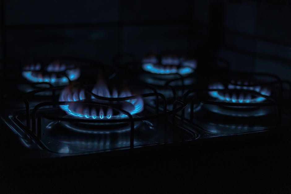 Stove burner won't light target outcome: dark atmospheric image capturing the blue flames of gas stove burners indoors, the healthy ignition you should see once the stove burner won't light problem is fixed