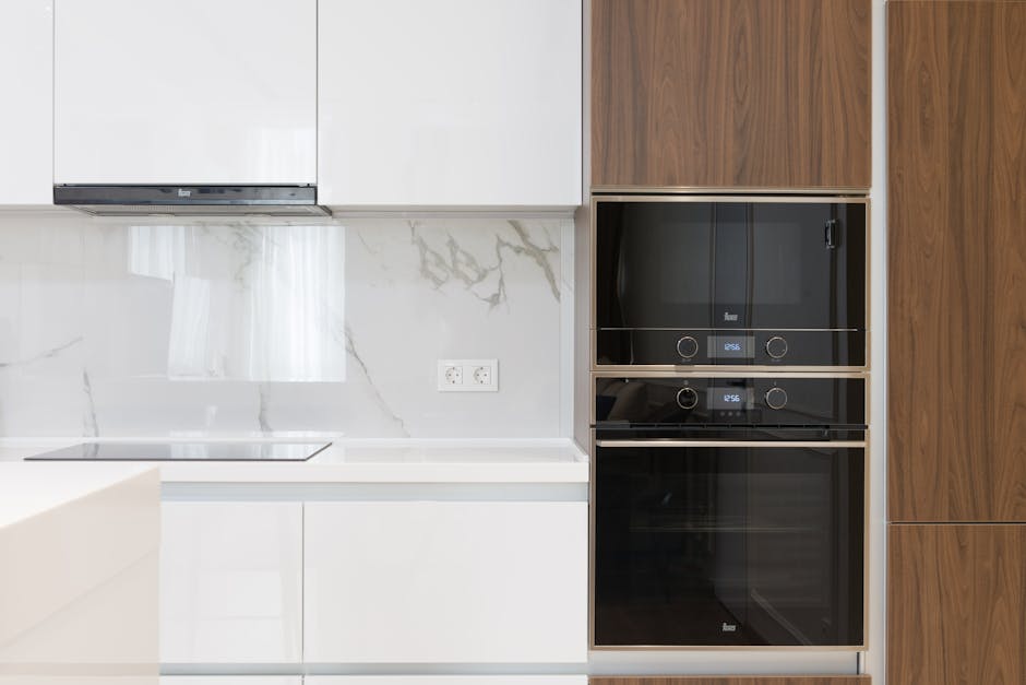 Microwave not heating repair context: modern white and wooden kitchen with cabinets and built-in appliances showing an over-the-range microwave installation