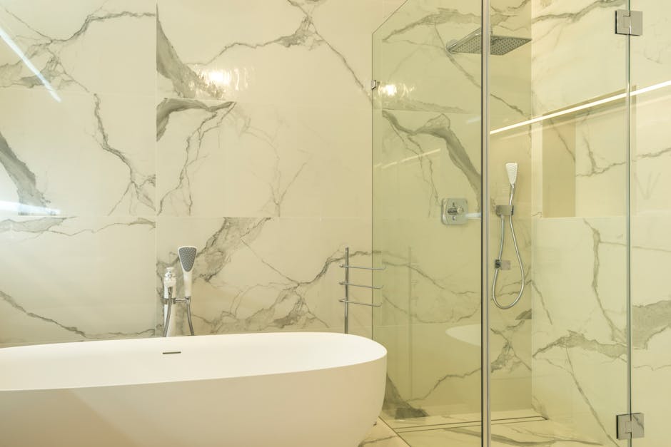 Shower drain smells outcome: luxurious marble bathroom featuring a modern bathtub and glass shower enclosure, the kind of clean fresh-smelling bathroom you want once the shower drain smells problem is solved