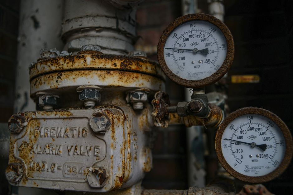 Water heater making noise valve check: a close-up of an aged pressure-relief valve and gauge assembly, the kind of fitting to inspect when a water heater making noise keeps chattering