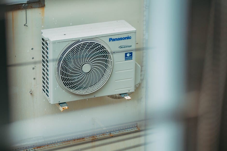 Heat pump not heating: outdoor heat pump-style HVAC unit mounted on the wall of a building, the typical homeowner setup for a heat pump not heating diagnosis