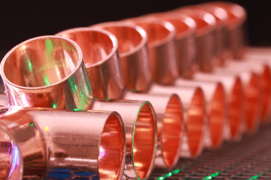 Water hammer: copper plumbing fittings arranged in a row showing the typical residential pipe materials where water hammer transients propagate