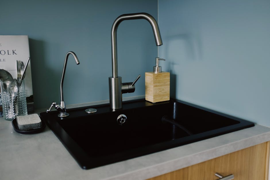 Clogged drain: stylish kitchen sink with chrome faucet and soap dispenser in a clean minimalist countertop setting