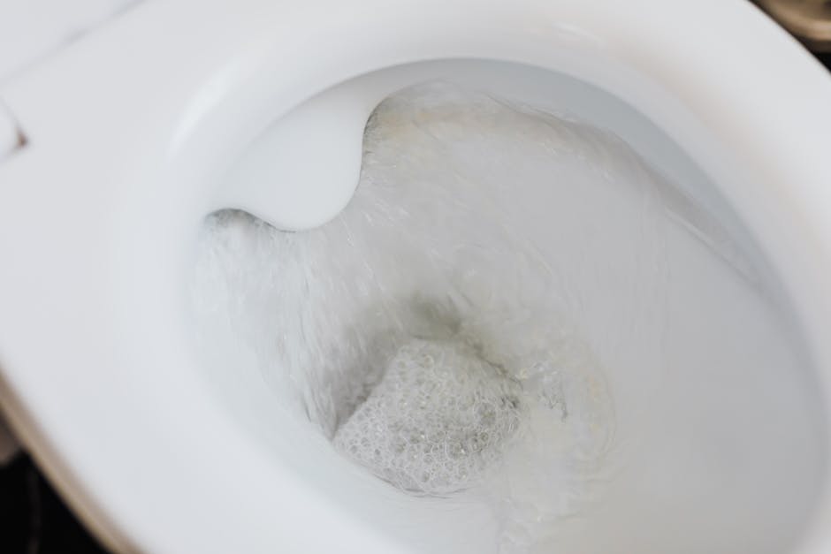 Toilet won't flush: high angle of a clean white ceramic toilet bowl with foamy flushing water, the target healthy flush you should see once a toilet won't flush problem is fixed