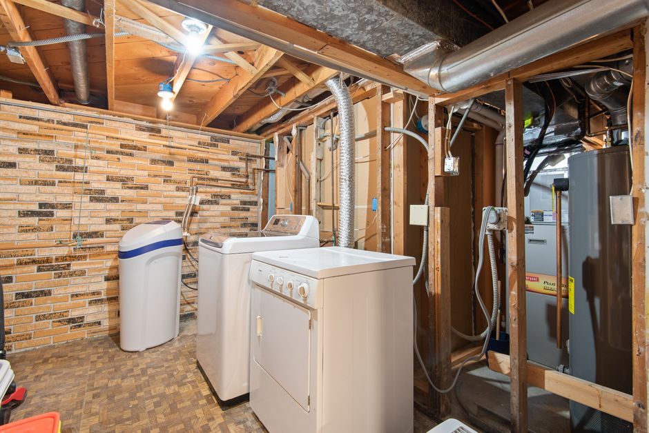 Water heater making noise: a clean utility and laundry area in a finished basement where a water heater making noise problem is typically diagnosed